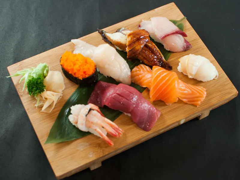 Creamy salmon roll topped with greens and fish roe at Sushi Feast AYCE, a Japanese Restaurant in Ocala